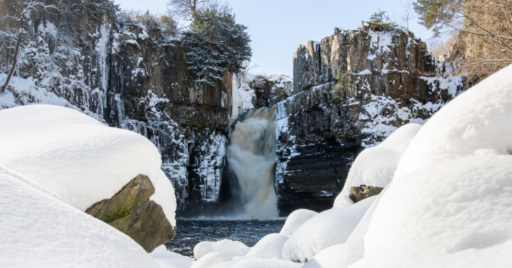View of High Force Waterfall covered in snow.